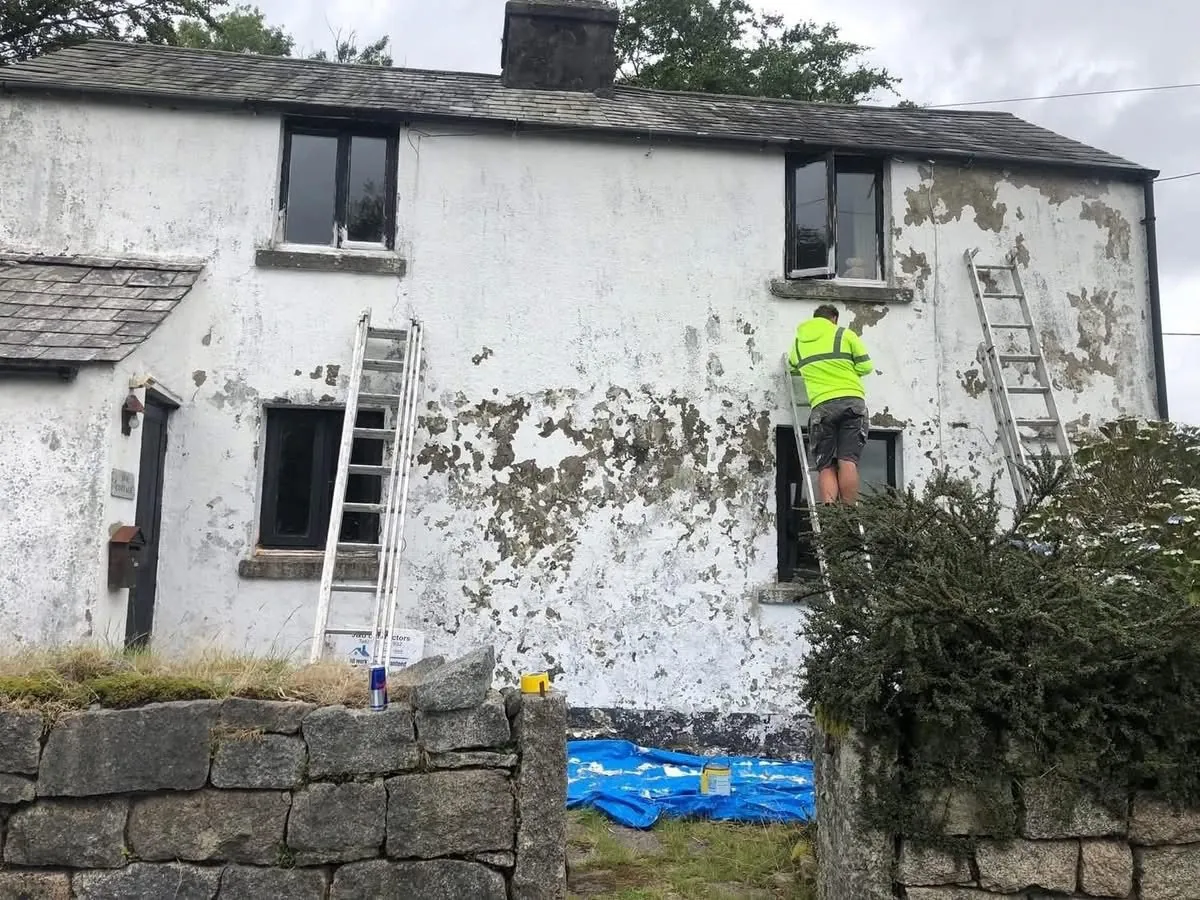 Cottage with blown, flaking render before repair in Axminster